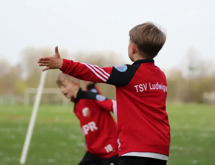 Jugendspieler des TSV Ludwigsfeld im roten Trikot auf dem Fußballplatz, passend zum Underdog im Münchner Norden mit Sport und Zusammenhalt.